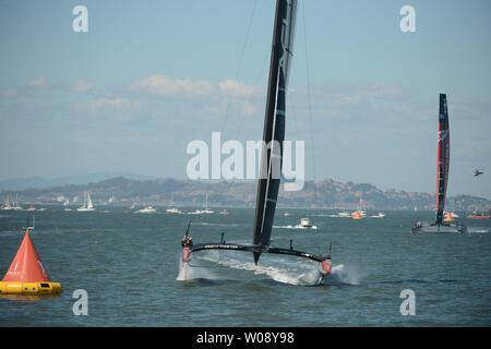 L'équipe américaine Oracle sails passé la ligne d'arrivée bien avant unis Nouvelle-zélande (R) je la race 15 de l'America's Cup sur la baie de San Francisco le 22 septembre 2013. Les Américains ont gagné 14 courses et 15 pour amener le score à 8-5 en faveur de l'Kiwis. UPI/Terry Schmitt Banque D'Images