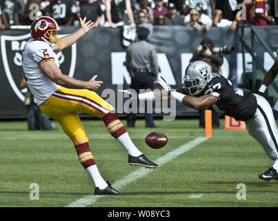 Oakland Raiders Rashad Jennings (R) bloque un punt par Redskins de Washington Sav Rocca (6) sur la ligne de but au premier trimestre chez O.co Coliseum à Oakland, Californie le 29 septembre 2013. Oakland recouvrés pour un TD. Les Redskins défait les Raiders 24-14. UPI/Terry Schmitt Banque D'Images