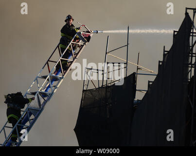 Les pompiers de verser de l'eau sur une alarme incendie de cinq logements en construction dans le quartier du bassin de la Chine de San Francisco le 11 mars 2014. UPI/Terry Schmitt Banque D'Images