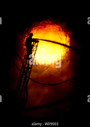 Le soleil qui brûle à travers la fumée que les pompiers, verser de l'eau sur un plan d'alarme de feu dans des appartements en construction dans le quartier du bassin de la Chine de San Francisco le 11 mars 2014. UPI/Terry Schmitt Banque D'Images