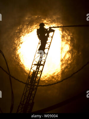 Le soleil qui brûle à travers la fumée que les pompiers, verser de l'eau sur un plan d'alarme de feu dans des appartements en construction dans le quartier du bassin de la Chine de San Francisco le 11 mars 2014. UPI/Terry Schmitt Banque D'Images