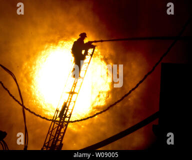 Le soleil qui brûle à travers la fumée que les pompiers, verser de l'eau sur un plan d'alarme de feu dans des appartements en construction dans le quartier du bassin de la Chine de San Francisco le 11 mars 2014. UPI/Terry Schmitt Banque D'Images