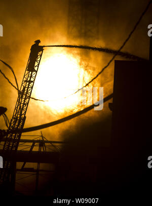 Le soleil qui brûle à travers la fumée que les pompiers, verser de l'eau sur un plan d'alarme de feu dans des appartements en construction dans le quartier du bassin de la Chine de San Francisco le 11 mars 2014. UPI/Terry Schmitt Banque D'Images