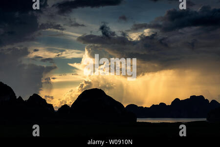 Scène sombre de tempête qui les nuages et la pluie obscurci la lumière du soleil sur les îles du golfe qui se profile sur Sametnangshe, Phangnga, Thaïlande. Banque D'Images