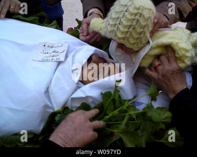 La famille syrienne se rassemblent autour du corps de Mohamad Mostfa Amar, auraient été tués par les forces gouvernementales syriennes, lors de funérailles dans al-qseer à Homs, Syrie, , le 25 mars 2012. Homs a été le lieu d'affrontements entre rebelles et troupes syriennes plus tôt ce mois-ci. Des dizaines de morts dans un bombardement de la région en février. UPI Banque D'Images