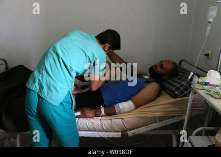 Un médecin syrien aide un homme blessé à l'hôpital. Après les frappes aériennes russes a frappé à Alep, province de Syrie le 21 mai 2016. La reprise des combats au cours des derniers jours, en particulier dans et autour d'Alep, a menacé l'effondrement d'un accord de cessez-le-feu, un point de repère dans les tentatives pour enfin régler un conflit qui a fait plus de 270 000 morts. Photo par Ameer Alhalbi/ UPI Banque D'Images