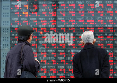 Comme la Bourse de Tokyo, le Nikkei a chuté en moyenne de 16 764,62 Mercredi, ou 79,88 points de moins que le jour précédent, deux hommes au regard du Conseil de l'action électronique à Tokyo, Japon, le 7 mars 2007. L'indice avait légèrement recoved mardi après la baisse de six jours, apparemment originaires de Chine a l'agitation. (Photo d'UPI/Keizo Mori) Banque D'Images