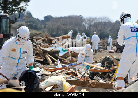 La police japonaise portant des tenues de protection contre les agents chimiques recherche de victimes à l'intérieur du rayon de 20 kilomètres autour de la centrale nucléaire de Fukushima Dai-ichi power plant à Minamisoma, préfecture de Fukushima, au Japon, le 15 avril 2011. Un tremblement de terre et le tsunami qui a suivi le 11 mars détruit les maisons, tué des milliers de personnes et causé une catastrophe nucléaire. UPI/Keizo Mori Banque D'Images