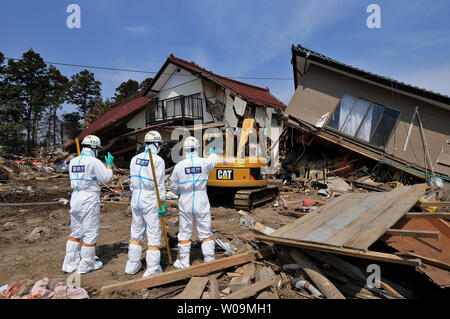 La police japonaise portant des tenues de protection contre les agents chimiques recherche de victimes à l'intérieur du rayon de 20 kilomètres autour de la centrale nucléaire de Fukushima Dai-ichi power plant à Minamisoma, préfecture de Fukushima, au Japon, le 15 avril 2011. Un tremblement de terre et le tsunami qui a suivi le 11 mars détruit les maisons, tué des milliers de personnes et causé une catastrophe nucléaire. UPI/Keizo Mori Banque D'Images