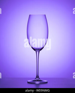 Verre de vin vide sur fond violet. close up. Banque D'Images