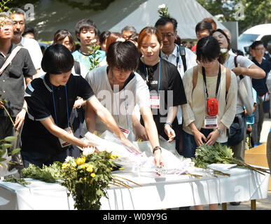 Les étudiants japonais et coréen Coréen offre des fleurs pour les victimes de la bombe atomique à Hiroshima Peace Memorial Park sur le 70e anniversaire de la bombe atomique à Hiroshima, Japon, le 5 août 2015. Photo par Keizo Mori/UPI Banque D'Images