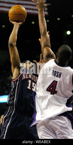 New Jersey Nets' Vince Carter prend la balle vers le panier que Toronto Raptors' Chris Bosh tente de bloquer au troisième trimestre l'action au Centre Air Canada le 15 avril 2005 à Toronto, Canada. Carter a marqué 39 points alors qu'il conduit les filets à une victoire 101-90 sur son ancienne équipe lors de sa première comparution de retour à Toronto après avoir été négociés. (Photo d'UPI/Christine Chew) Banque D'Images