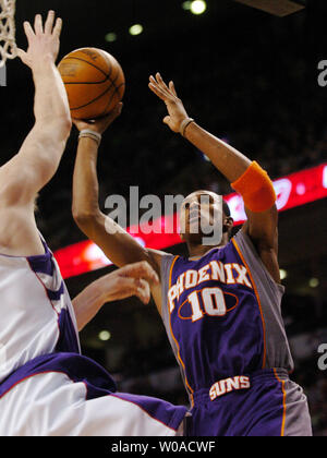 Phoenix Suns' Leandro Barbosa passe à faire un layup sur le bras tendu de Toronto Raptors' Matt Bonner au deuxième trimestre l'action au Centre Air Canada à Toronto, Canada le 31 mars 2006. Les Suns a défait les Raptors 140-126. (Photo d'UPI/Christine Chew) Banque D'Images