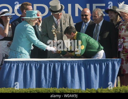 Woodbine Entertainment Group Président David Wilmot détient le trophée gagnants comme le Queen's Plate Stakes Eurico jockey gagnant da Silva s'incline tout en serrant la main de la Reine Elizabeth de la Grande-Bretagne dans le cercle des gagnants à Woodbine Race Track, près de Toronto, Ontario, le 4 juillet 2010. La Reine et le Prince Philip au jour sept de leurs neuf jour tournée royale au Canada. UPI/Heinz Ruckemann Banque D'Images