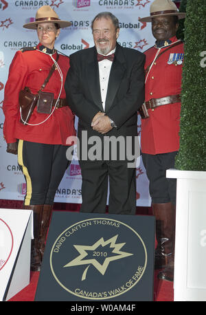 Flanqué de gardes d'honneur, membre de la GRC, David Clayton-Thomas, le chanteur principal de la bande du sang, de la sueur et des larmes, des sourires en se tenant debout sur son prix à l'extérieur de la plaque lors de l'édition 2010 du Théâtre Canon Canada Walk of Fame Hommage au centre-ville de Toronto, Ontario, le 16 octobre, 2010. /Photo UPI Heinz Ruckemann Banque D'Images