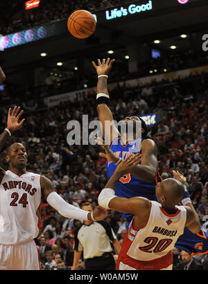 New York Knicks' Bill Walker (centre) prend une chance au hoop comme il est double-associé par Toronto Raptors' Leandro Barbosa (R) et Sonny Weems au premier trimestre de l'action des rapaces d'ouverture à domicile au Centre Air Canada à Toronto, Canada le 27 octobre 2010. Les Knicks défait les Raptors 98-93. UPI /Christine Chew Banque D'Images