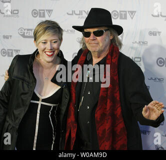 Neil Young (R) arrivent sur le tapis rouge avec un compagnon, au Juno Awards diffusée au Centre Air Canada au cours de la remise des Prix Juno 2011 à Toronto, Ontario, le 27 mars 2011. /Photo UPI Heinz Ruckemann Banque D'Images