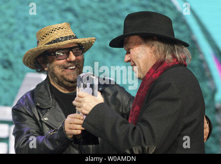 Neil Young (R) reçoit le Prix humanitaire Allan Waters de son ami et collègue Daniel Lanois, au Juno Awards diffusée au Centre Air Canada au cours de la remise des Prix Juno 2011 à Toronto, Ontario, le 27 mars 2011. /Photo UPI Heinz Ruckemann Banque D'Images