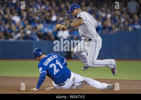 Les Rangers du Texas Elvis Andrus, droite, évite des Blue Jays de Toronto Michael Saunders pour un chassé à la deuxième base en quatrième manche du jeu 3 de l'ALDS, au Centre Rogers à Toronto, Canada, le 9 octobre 2016. Photo par Darren Calabrese/UPI Banque D'Images