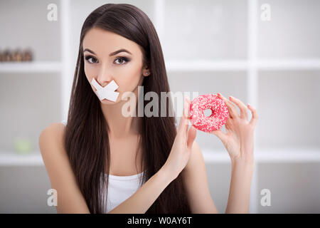 Régime alimentaire. Close up visage de jeune belle femme latine triste avec la bouche scellée sur stick tape Banque D'Images