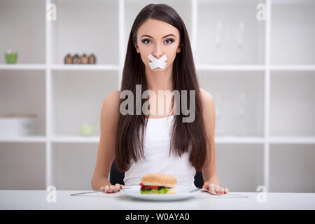 Régime alimentaire. Close up visage de jeune belle femme latine triste avec la bouche scellée sur stick tape Banque D'Images