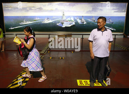 Les touristes chinois visiter le porte-avions de Binhai, parc à thème avec l'ex-Fédération de gros avions cruiser le Kiev, à Tianjin le 29 juillet 2014. Le Kiev a été un porte-avions lourds cruiser qui a servi la marine russe et soviétique de 1975 à 1993 avant d'être vendu à une société chinoise en 1996 pour une utilisation dans un parc à thème militaire. Plus de 15,5 millions de dollars ont été consacrés à la restauration et à l'équipement de la ex-navire en un hôtel de luxe développé par Tourisme et loisirs consultant attraction Quest International (USA). UPI/Stephen Shaver Banque D'Images