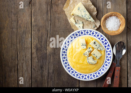 La cuisine italienne, la polenta avec du fromage gorgonzola sur table en bois. Vue d'en haut. Banque D'Images