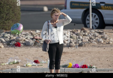 Une femme attend pour traverser la rue après avoir quitté fleurs au Mémorial de fortune un jour après qu'un jeune homme tué six personnes y compris le juge de district américain John Roll et gravement blessé représentant Gabrielle Giffords U.S à Florence, Arizona le 9 janvier 2011. La tentative d'assassinat a eu lieu près d'un nord de Safeway de Tucson le 8 janvier 2011. UPI/Gary C. Caskey Banque D'Images