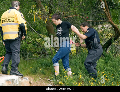 La police arrête un manifestant à la réfection de la route des falaises Johnson Pueblo blocus dans West Vancouver (Colombie-Britannique), le 25 mai 2006. A plus d'un mois, la construction de la route à travers les terres écologiquement sensibles par l'entreprise américaine Peter Kiewit Sons fait partie d'un projet visant à améliorer l'autoroute Sea-to-Sky à temps pour les Jeux Olympiques d'hiver de 2010. (Photo d'UPI/Heinz Ruckemann) Banque D'Images