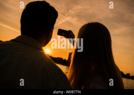 Heureux couple prend en selfies coucher de soleil dans la ville. Banque D'Images