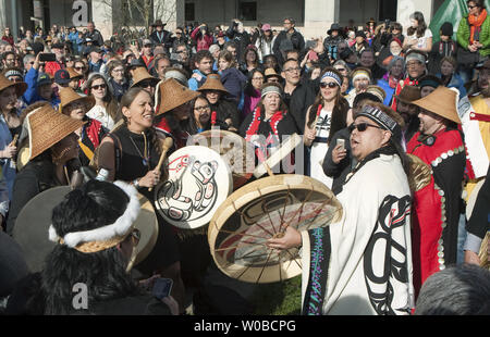 Les Premières nations drummers effectuer avant les 17 mètres de hauteur de la réconciliation totem sculpté par James Hart (7idansuu), maître sculpteur haida et le chef héréditaire est installé sur le centre commercial principal de l'Université de la Colombie-Britannique (UBC) à Vancouver, en Colombie-Britannique (C.-B.) le 1er avril 2017. Le totem représente les survivants des pensionnats. UPI/Heinz Ruckemann Banque D'Images