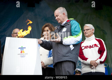 Le Premier Ministre de la Colombie-Britannique Gordon Campbell montres comme directeur général du COVAN, John Furlong contribue à Darlene Poole la lumière 1,2 mètres chaudron de célébration communautaire avec la flamme olympique à l'Assemblée législative de la Colombie-Britannique où les premiers porteurs de la flamme olympique d'hiver de 2010 commencera à Victoria (Colombie-Britannique) le 30 octobre 2009. UPI / Phillip Chin Banque D'Images