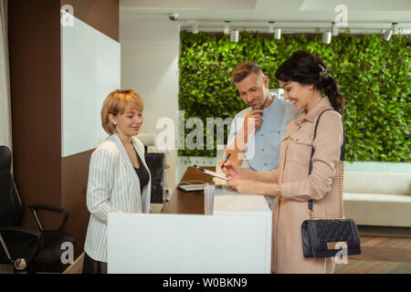 Mari se joindre à sa femme de venir à la clinique pour consultation beauté Banque D'Images