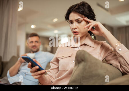 Dark-haired woman sentiment inquiet avant de rencontrer le chirurgien de plastique Banque D'Images