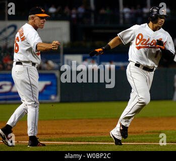 Les Baltimore Orioles Brian Roberts est félicité par l'entraîneur de troisième Tom Trebelhorn après avoir frappé un coup de circuit en solo en troisième manche contre les Minnesota Twins Carlos Silva le 22 août 2006, à l'Oriole Park at Camden Yards de Baltimore (MD), les Orioles défait les jumeaux 6-3. (UPI Photo/Mark Goldman) Banque D'Images