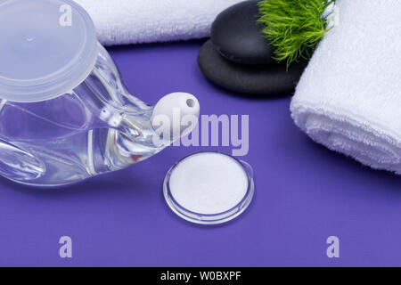 Spa fond violet avec Pot Neti, pieu de Saline, roulé les serviettes blanches et pierres de basalte empilées. Lavage de sinus. L'irrigation nasale. Banque D'Images