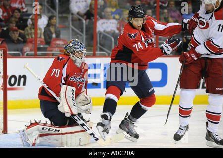 Gardien Braden Holtby Les Capitals de Washington (70) fait une sauvegarde sur un tir de Jordan Staal centre Carolina Hurricanes (11) Car qui est par le défenseur John Carlson (74) dans la première période à la Verizon Center à Washington, D.C. le 10 octobre 2013 dans les capitales d'ouverture à domicile. UPI/Mark Goldman Banque D'Images