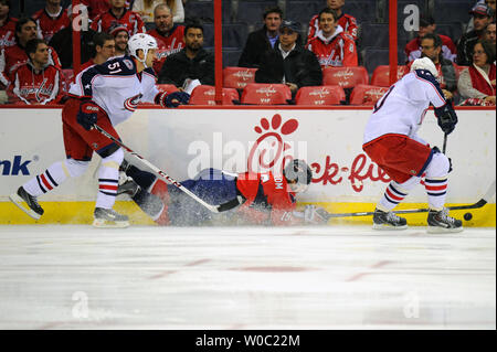 Les Capitals de Washington Nicklas Backstrom centre (19) est pris pour la glace par Columbus Blue Jackets défenseur Fedor Tyutin (51) dans la première période à la Verizon Center à Washington, D.C. le 12 novembre 2013. UPI/Mark Goldman Banque D'Images