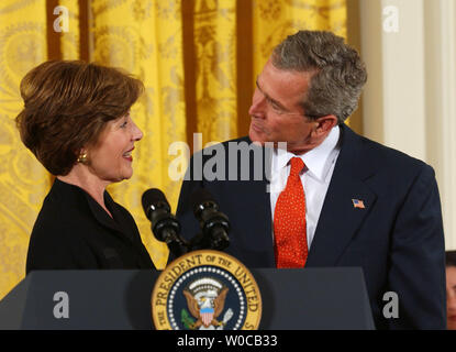 Le Président George Bush partage un moment avec la Première dame, Laura Bush après qu'elle lui a présenté un événement international pour les droits des femmes, à la Maison Blanche le 12 mars 2004 à Washington. Le président a dit que des progrès ont été réalisés dans des endroits comme le Moyen-Orient, mais qu'il reste encore beaucoup à faire. (Photo d'UPI/Michael Kleinfeld) Banque D'Images