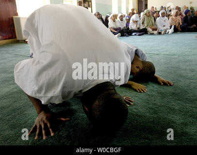 Un père et son fils, prier au cours de la prière du vendredi à la mosquée Masjid Muhammad le 26 mars 2004 à Washington DC. Le centre-ville Washington mosquée est essentiellement africaine-américaine aujourd'hui, mais comprend une importante population immigrée en provenance d'Afghanistan, le Sénégal, et la Palestine. La mosquée a été fondée à l'origine par la Nation de l'Islam, mais plus pratiques et enseigne les locataires traditionnels de l'Islam sunnite d'aujourd'hui. (Photo d'UPI/Michael Kleinfeld) Banque D'Images