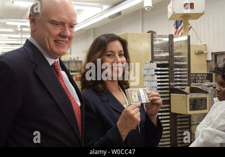 Le secrétaire du Trésor, John W. Snow montres comme nouveau Trésorier Anna Escobedo Cabral est titulaire d'un lot de la première de l'argent qui a été imprimé avec Cabral la signature à la U.S. Bureau of Engraving and Printing à Washington le 26 avril 2005. (Photo d'UPI/Roger L .Wollenberg) Banque D'Images