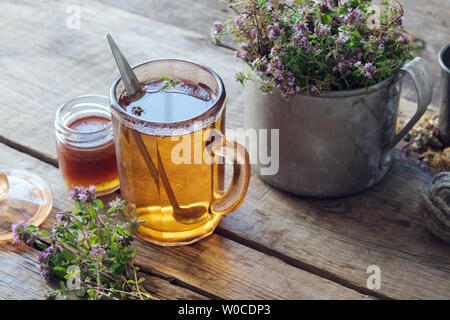 Tasse de tisane de thym miel sain, jar et rustique metal tasse pleine de Thymus serpyllum herbes médicinales. Banque D'Images
