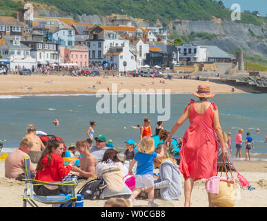 Lyme Regis, dans le Dorset, UK. 27 juin 2019. Météo France : Sunseekers se rendent dans la pittoresque station balnéaire de Lyme Regis pour profiter du soleil brûlant et lumineux ciel bleu comme la canicule saharienne hits au Royaume-Uni. Les visiteurs et les habitants se prélasser au soleil torride sur la plage de sable de la ville. Credit : Celia McMahon/Alamy Live News. Banque D'Images