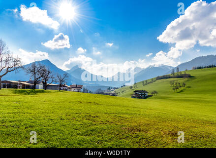 Vue sur les alpes bavaroises et brandengerg, champs verts avec ciel bleu au coucher du soleil. Près de Thiersee, Heiterwang, Orange, Wendelstein, Kufstein, Bavar Banque D'Images