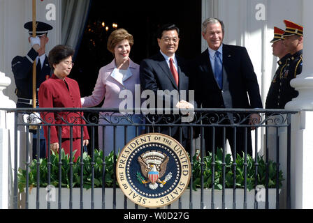 Le président américain George W. Bush (R), serre la main avec le président chinois Hu Jintao, alors que premier land Laura Bush (deuxième à gauche) et l'épouse de Jintao Madame Liu Yongqing participer à une pelouse Sud Cérémonie d'arrivée à la Maison Blanche le 20 avril 2006. Les espoirs des États-Unis pour le soutien de la Chine à dissuader la Corée du Nord et les ambitions nucléaires de l'Iran et en même temps à des changements dans les politiques économiques de la Chine. (UPI Photo/Kevin Dietsch) Banque D'Images