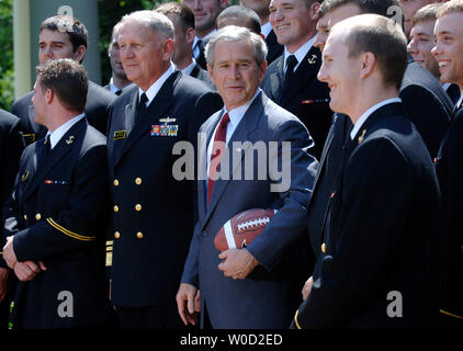 Le Président George Bush pose avec les membres de l'Académie navale américaine men's football team, lors d'une cérémonie où il a reçu l'équipe le commandant en chef's Trophy, à Washington le 25 avril 2006. Le commandant en chef's Trophée est décerné à chaque saison pour le gagnant de la série de football collégial triangulaire entre l'Académie militaire, la United States Naval Academy, et l'United States Air Force Academy. (UPI Photo/Kevin Dietsch) Banque D'Images