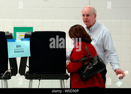 Le jour de l'élection (McCall Allen bénévoles R) aide l'électeur avec le vote électronique par machine qu'elle vote en 2006 l'élection de mi-mandat, à Baileys École élémentaire pour les arts et les sciences à Falls Church, en Virginie, le 7 novembre 2006. (UPI Photo/Kevin Dietsch) Banque D'Images