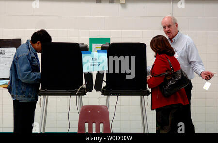 Le jour de l'élection (McCall Allen bénévoles R) aide l'électeur avec le vote électronique par machine qu'elle vote en 2006 l'élection de mi-mandat, à Baileys École élémentaire pour les arts et les sciences à Falls Church, en Virginie, le 7 novembre 2006. (UPI Photo/Kevin Dietsch) Banque D'Images