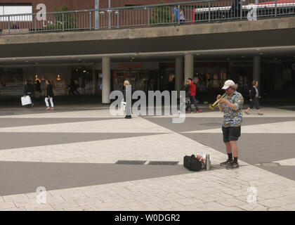 Un homme seul en shorts et les joue sur une trompette à Sergels torg, dans le centre de Stockholm, Suède Banque D'Images