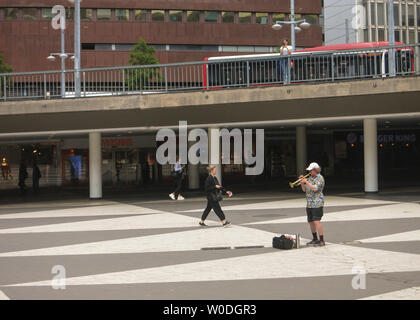 Un homme seul en shorts et les joue sur une trompette à Sergels torg, dans le centre de Stockholm, Suède Banque D'Images